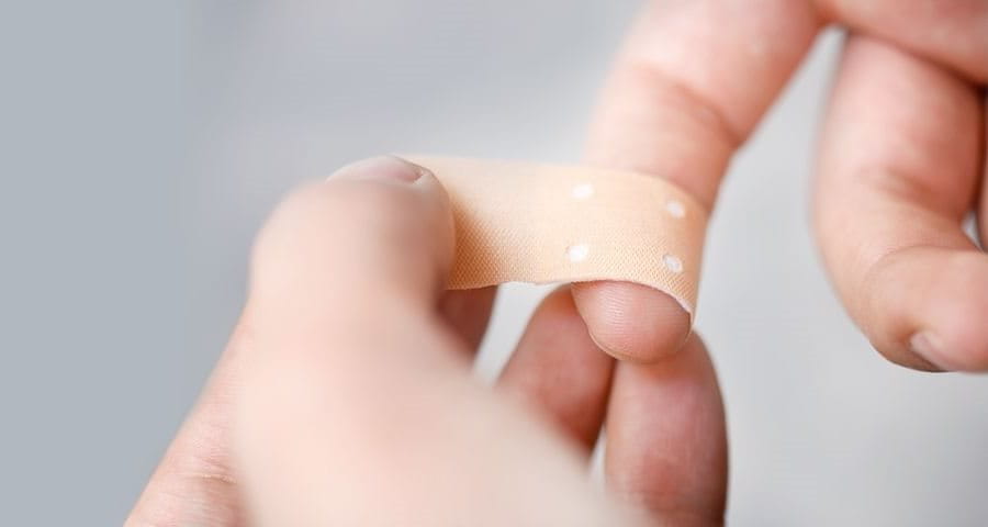 Plaster being applied on a finger - Elastoplast