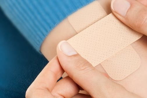 Person applying platers on an arm - banner - Elastoplast