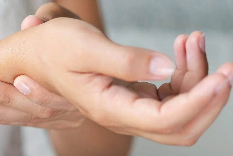 Women holding her wrist with the other hand