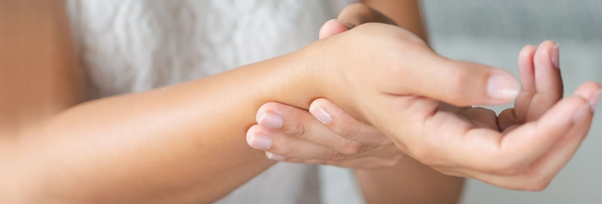 Γυναίκα που κρατάει τον καρπό της με το άλλο χέρι