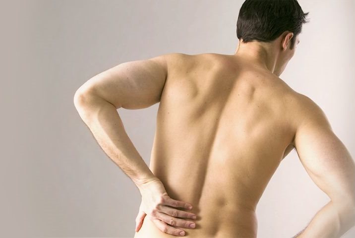 Mann hält sich den schmerzenden Rücken