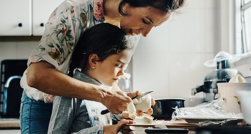 Mother and daughter in kitchen preparing fruit