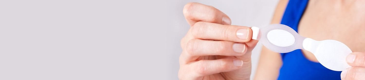 Frau die das Schutzpapier von einem transparenten Pflaster abzieht