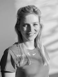 Woman in sportswear faces the camera in greyscale