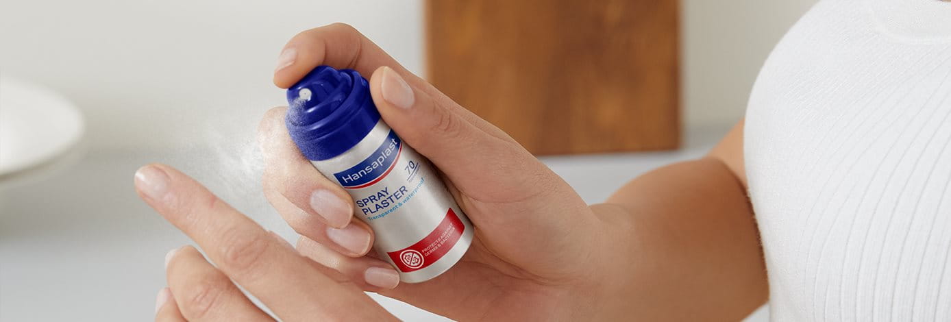 Hand mit Sprühpflaster Dose