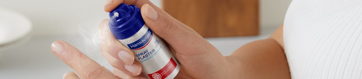 Hand mit Sprühpflasterdose