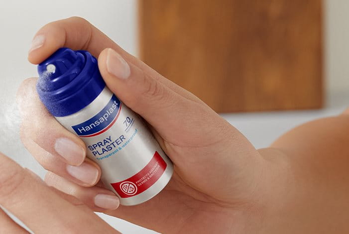 Hand mit Sprühpflaster Dose