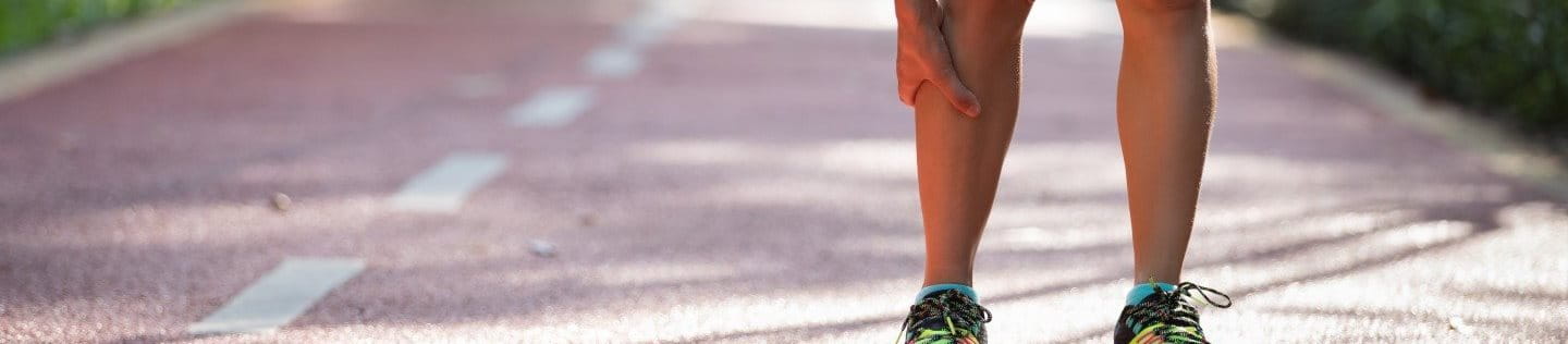 Läufer greift an Bein