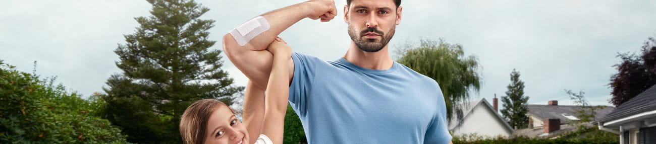 Mann trägt Kind auf Bizeps