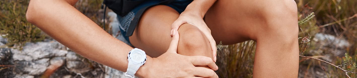 Sportlerin greift auf schmerzendes Knie