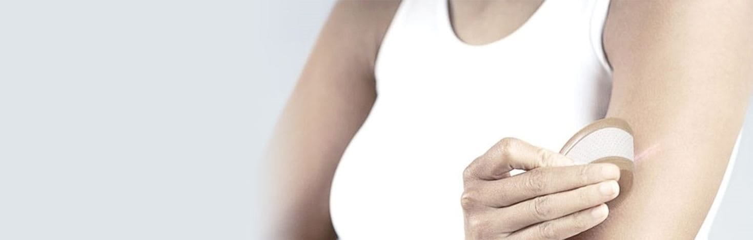 Une femme applique un pansement pour prévenir la formation de cicatrices sur une plaie.