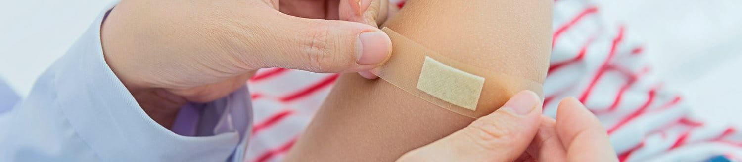 Ein Kind bekommt ein Pflaster auf den Oberarm aufgeklebt