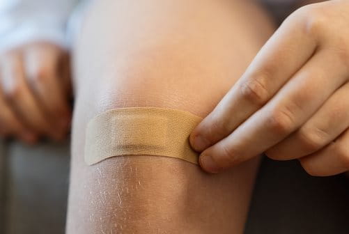 Junge mit Pflaster am Knie