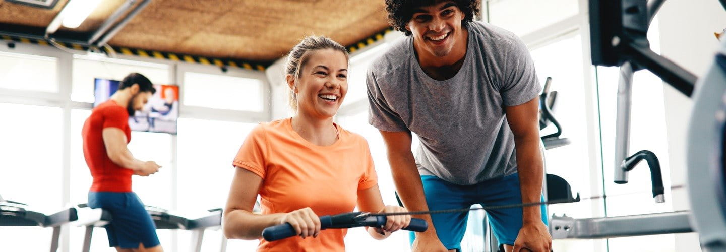Frau trainiert an Rudermaschine im Fitnessstudio