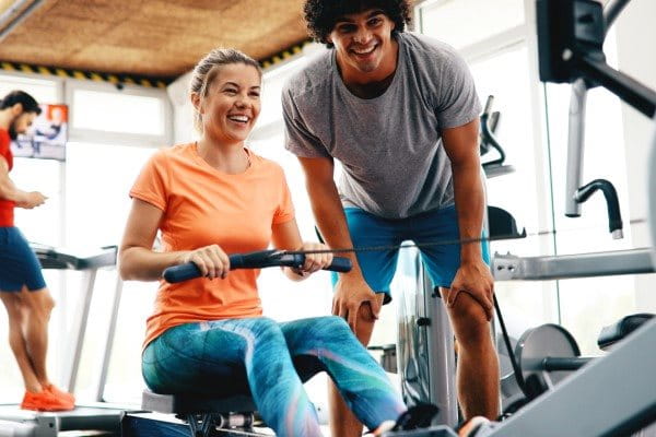Frau trainiert an Rudermaschine im Fitnessstudio
