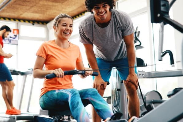 Frau trainiert an Rudermaschine im Fitnessstudio