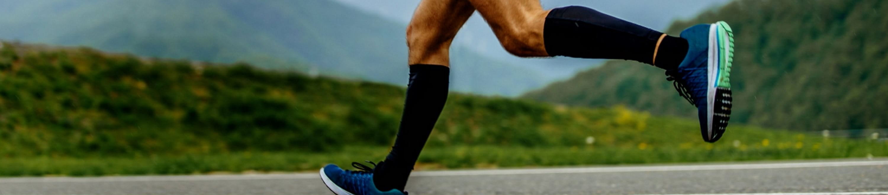 Mann läuft mit Kompressionskleidung auf der Straße