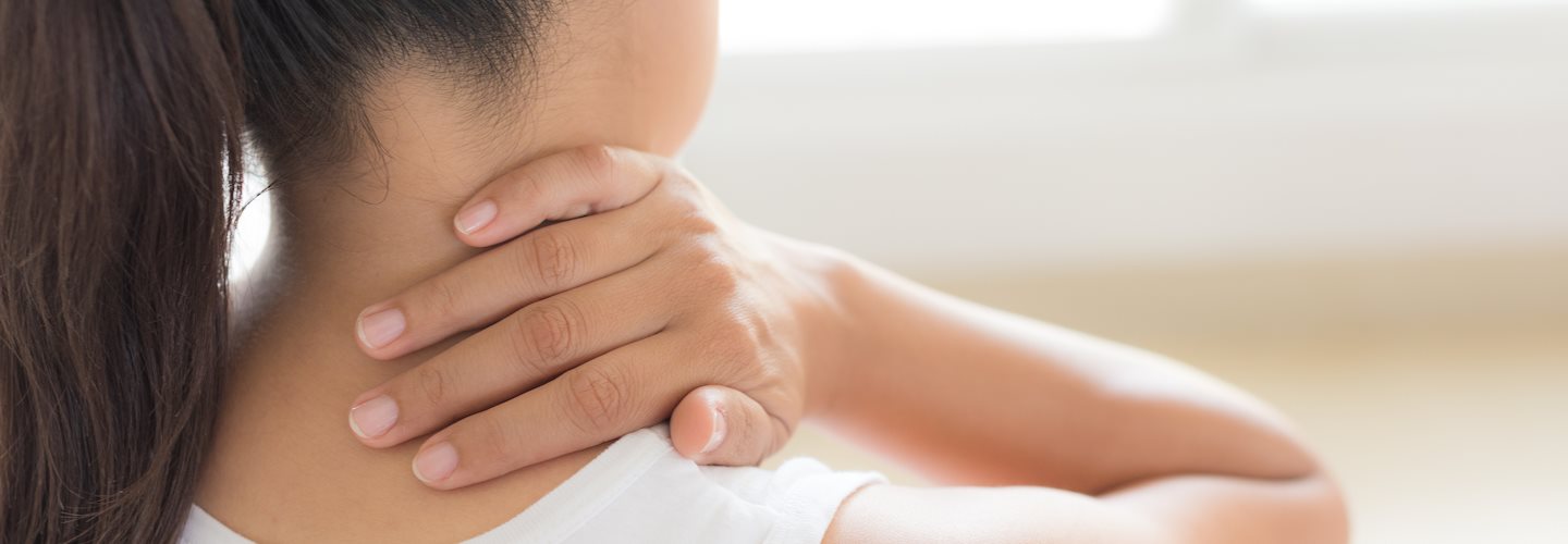 Frau legt Hand auf Nacken