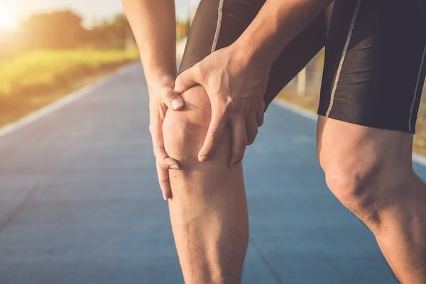 Mann hält sich Knie mit Patellaspitzensyndrom