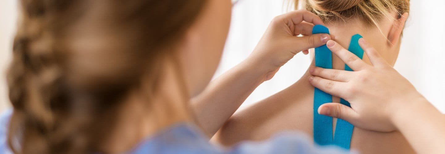 Einer Frau werden Nacken und Rücken getapt