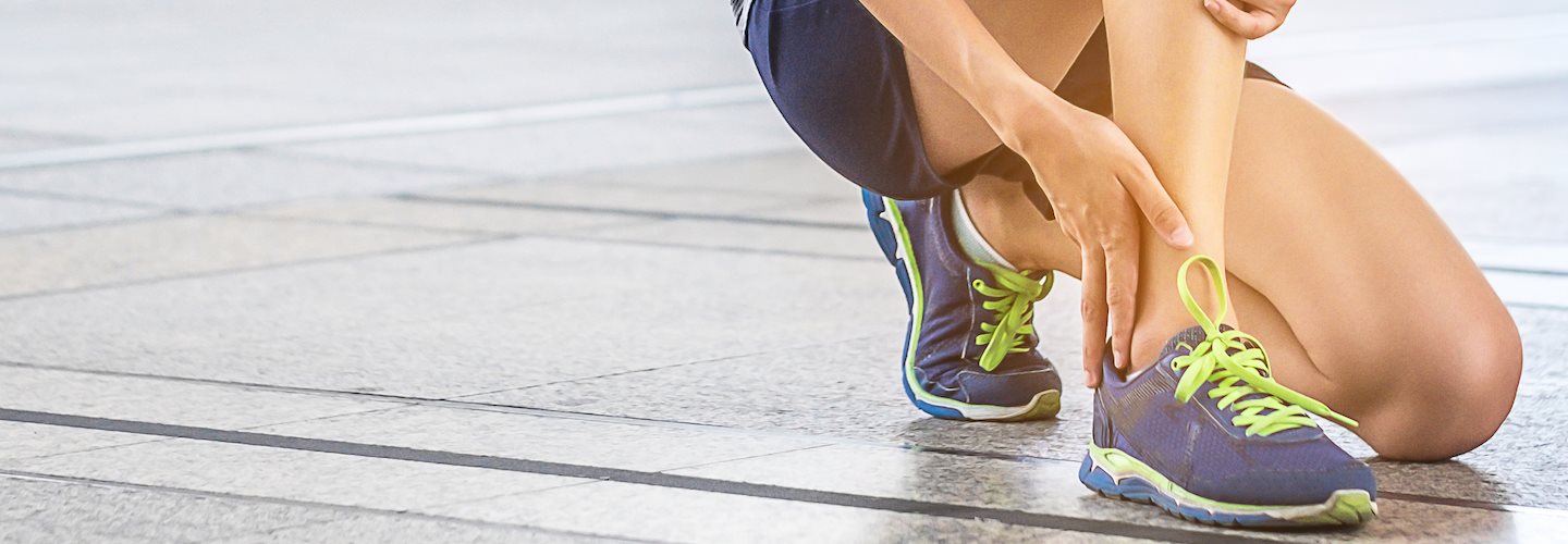 Junge Frau tastet Knöchel ab