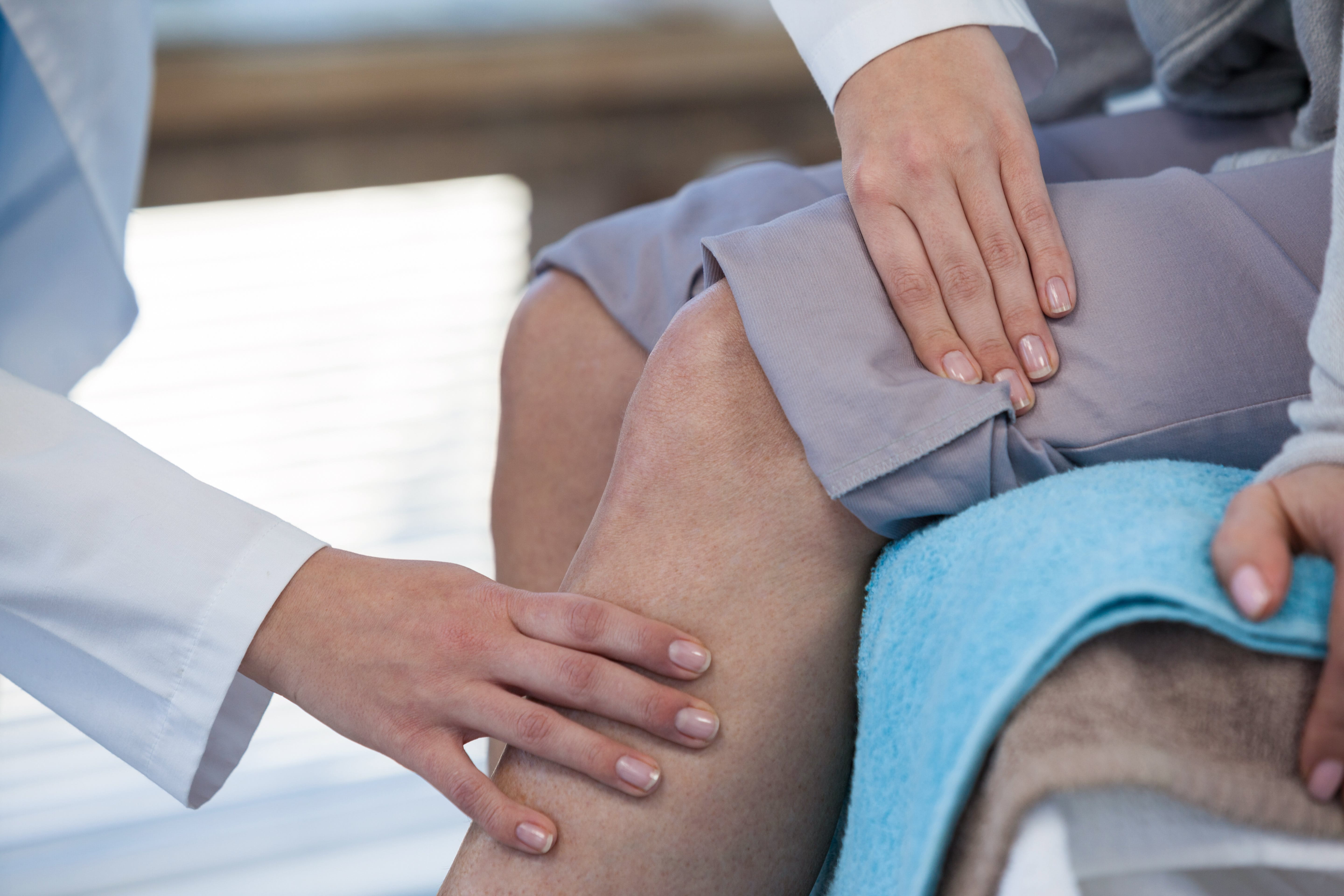 a doctor examining a person’s knee