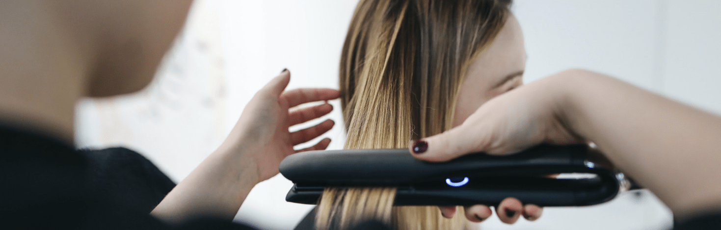 Lady using a hair straightener.