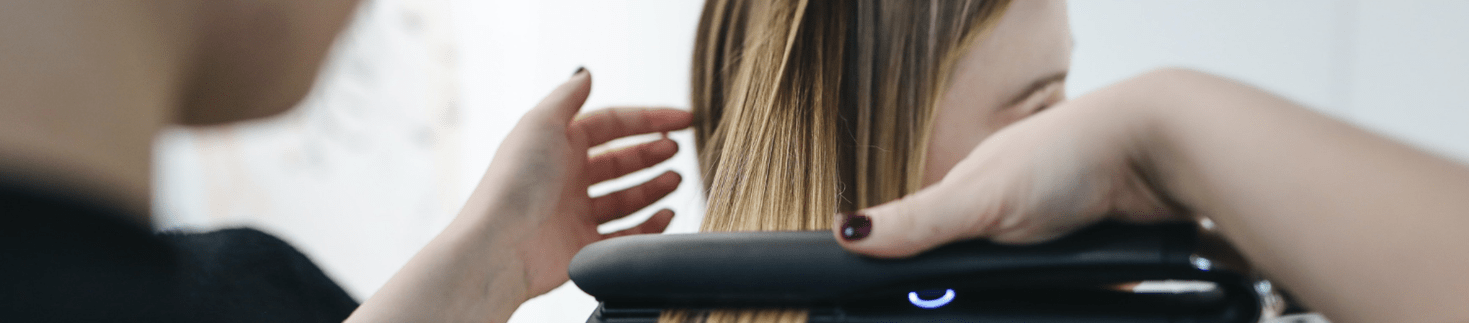 Lady using a hair straightener.