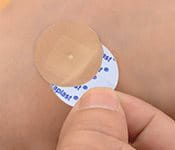 Remove the second release liner from the plaster and apply it over the wound