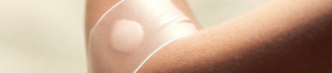 Close-up shot of a wound on an arm dressed up using Elastoplast plasters that leverage hydrocolloid technology.