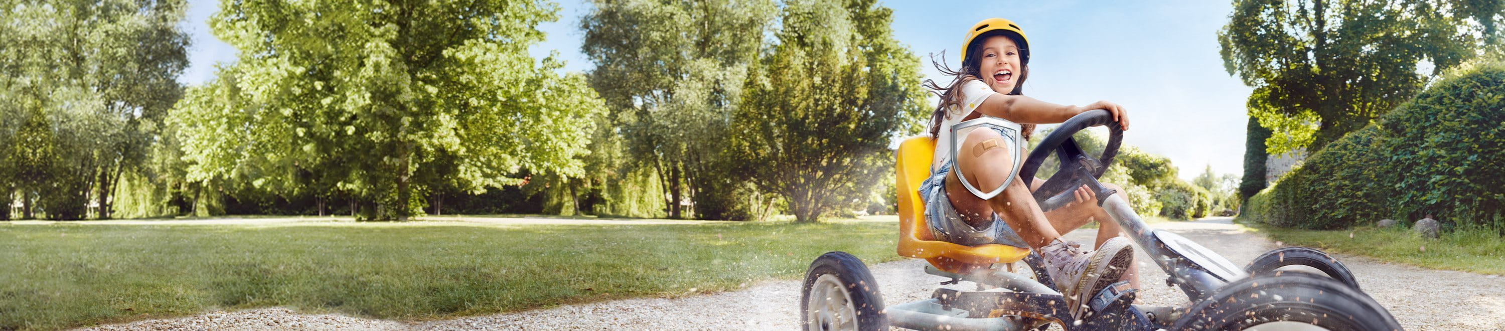 Kind fährt mit einem Pflaster auf dem Knie Go-Kart