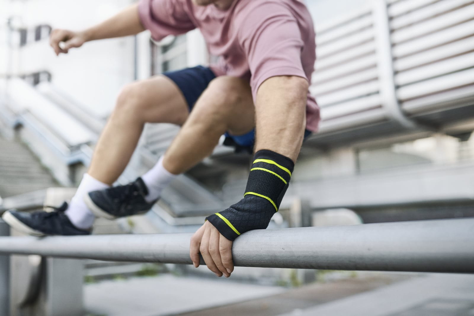 man jumping over railing with wrist support