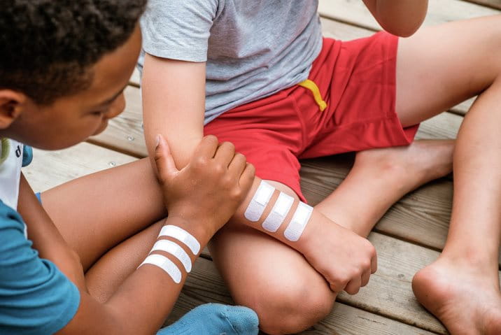 A young girl with dirt-covered hands but a clean plaster