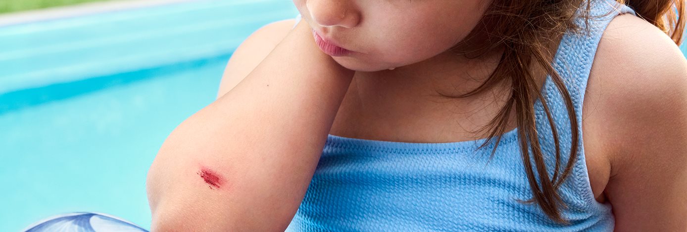 Detailansicht einer Person, die ein Pflaster auf den Zeigefinger klebt.