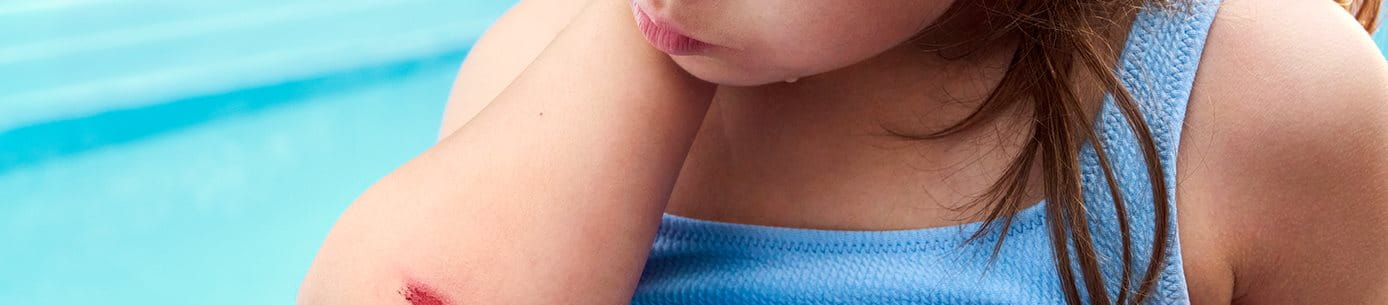 Detailansicht einer Person, die ein Pflaster auf den Zeigefinger klebt.