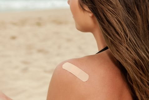 Junge Frau mit einem Pflaster auf der Schulter