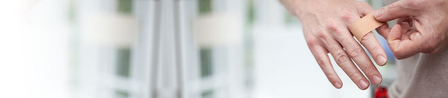 Handwerker klebt Pflaster auf seinen Finger