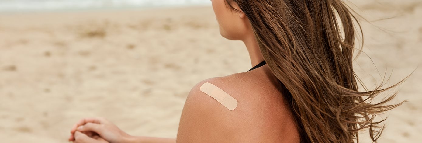 junge Frau mit einem Pflaster auf der Schulter