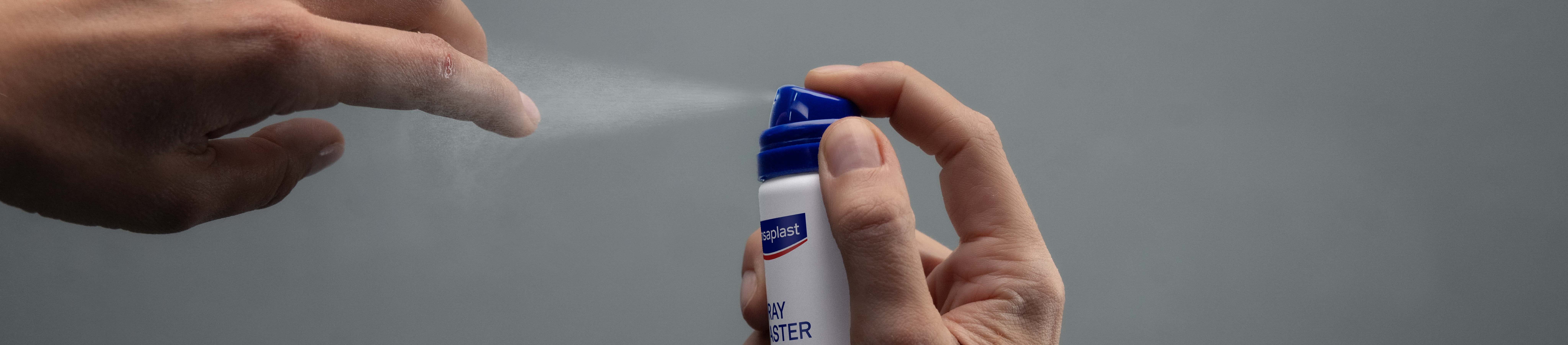 Personne appliquant Hansaplast Second Skin Protection Spray Plaster sur le bout de son doigt