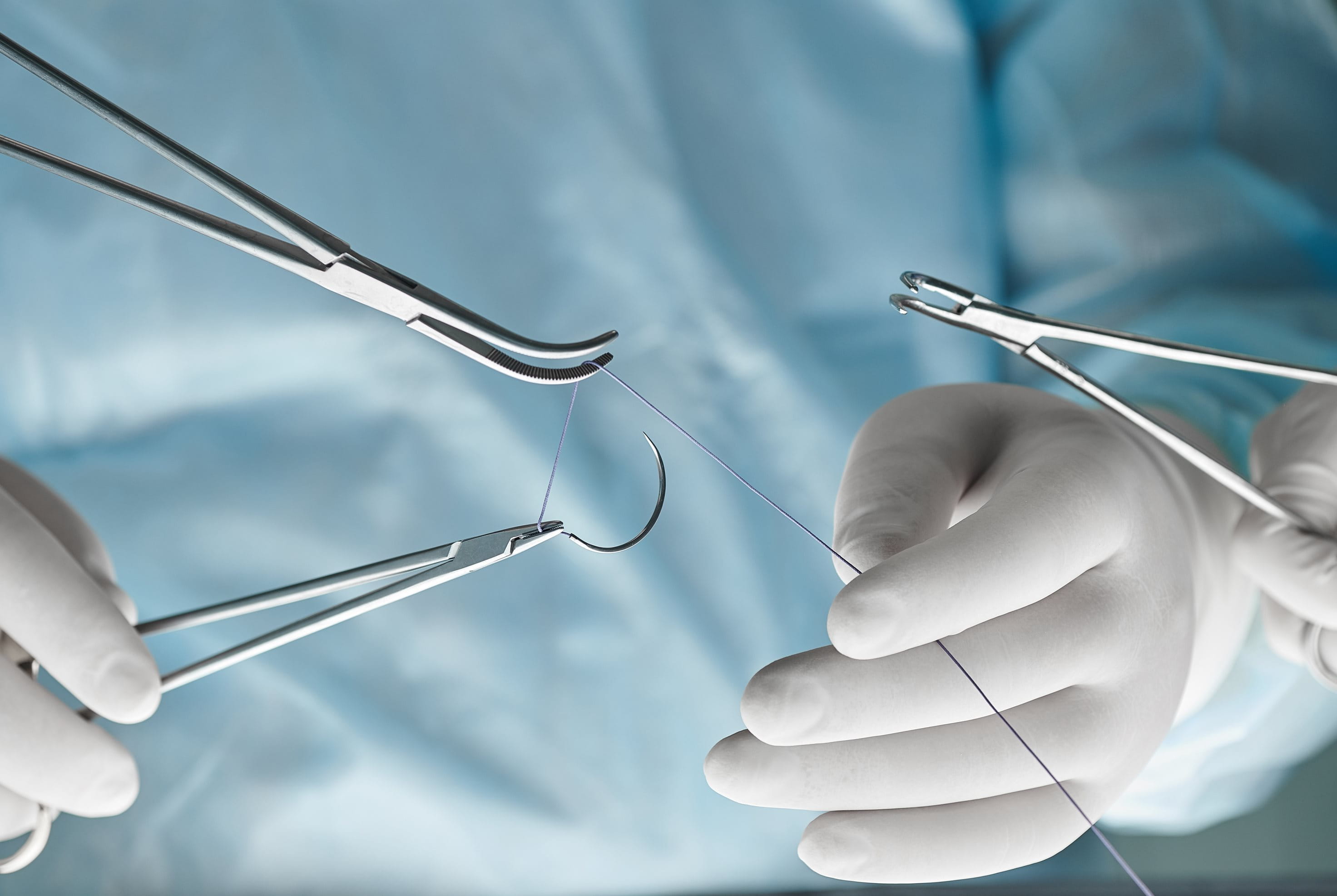 Chirurgenhände mit OP Besteck