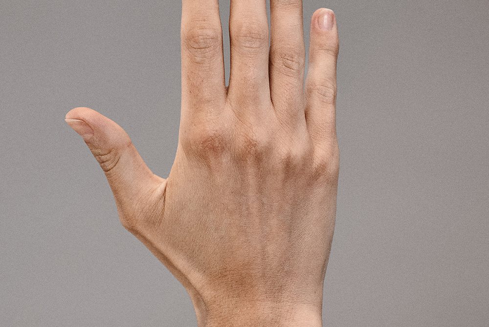 Hände mit gesunder Nagelhaut und mit Feuchtigkeit versorgter Haut, die gepflegte Finger zeigen.