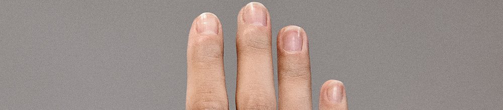 Hände mit gesunder Nagelhaut und mit Feuchtigkeit versorgter Haut, die gepflegte Finger zeigen.