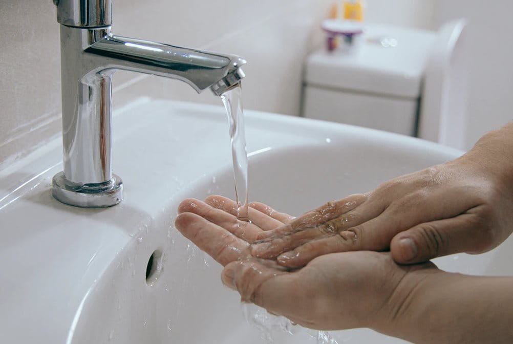 Membersihkan tangan dengan air