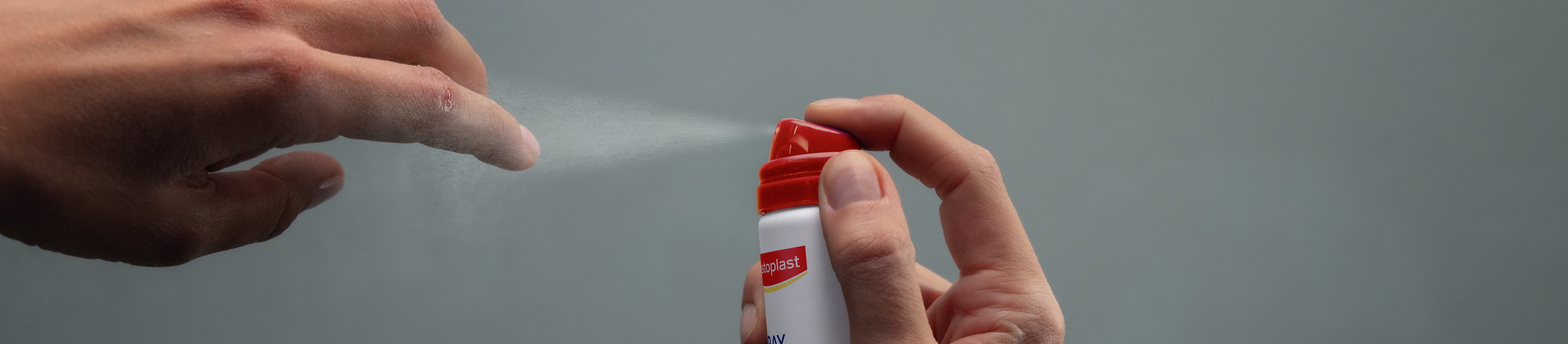 Persona aplicándose el Hansaplast Second Skin Spray Plaster en la yema del dedo
