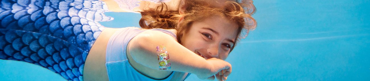 A young child's reflection in a body of water, slightly distorted as ripples spread across the water.