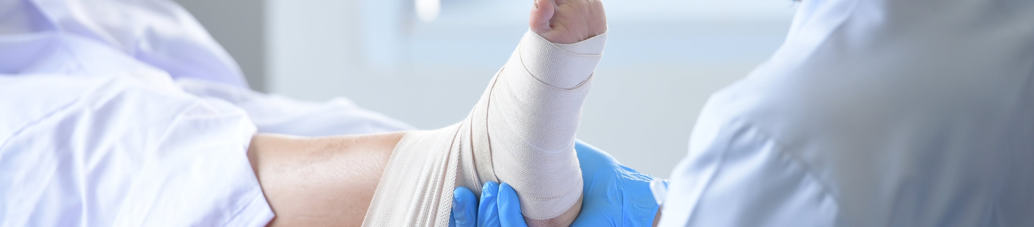 Arzt verbindet den Fuss eines Patienten
